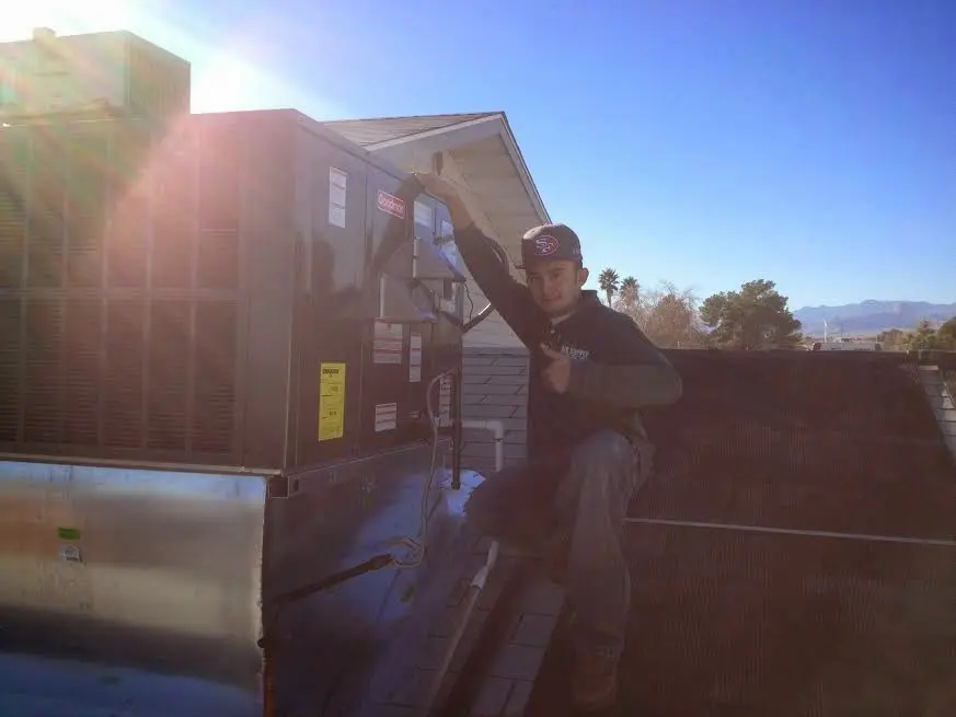 HVAC technician performing Air Duct Cleaning on a rooftop unit in Rossville